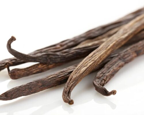 Vanilla beans on a white surface.